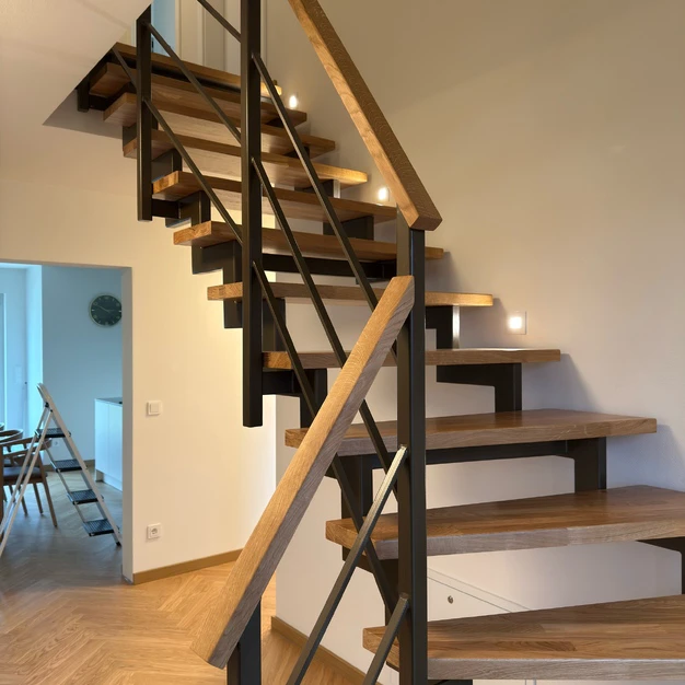 Moderne Treppe mit Holztrittern und schwarzem Metallgeländer in einem zeitgenössischen Interieur
