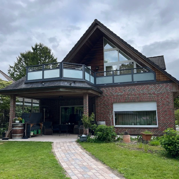 Modernes Backsteingebäude mit steilem Satteldach großem Glas und gepflastertem Pfad im Vorgarten