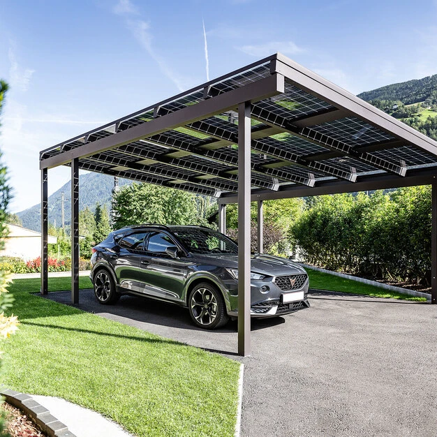 Ein modernes Auto unter einer solaren Überdachung mit grüner Umgebung und Bergkulisse