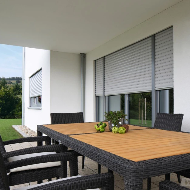 Blick auf eine moderne Terrasse mit Esstisch Stühlen und Hintergrundpanorama