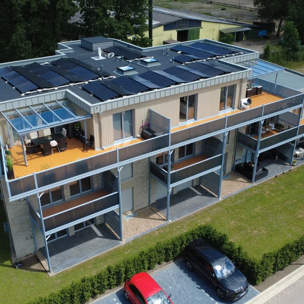 Modernes zweistöckiges Haus mit Solarpaneelen Balkonen und geparkten Autos