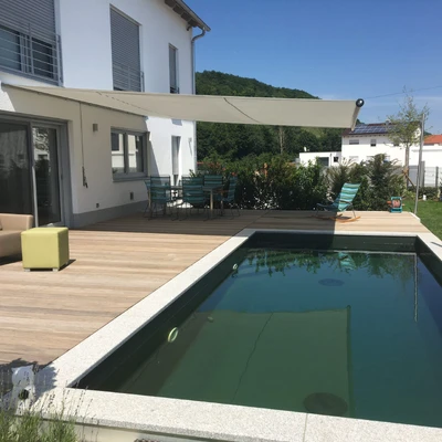 Pool, Terrasse und modernes Haus an sonnigem Tag