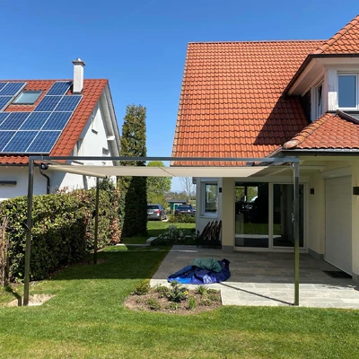 Moderne Häuser mit Solarpanelen und Überdachung im Garten