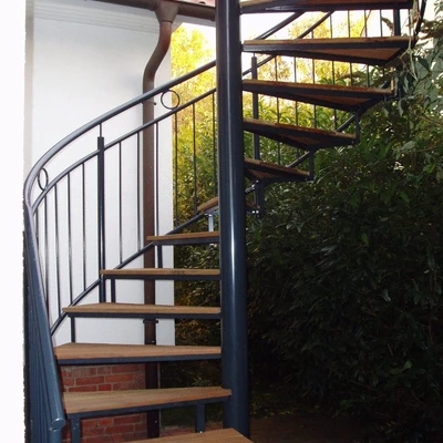 Schwarze freistehende Treppe mit Holzstufen im Außenbereich