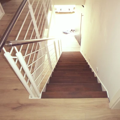 Nachwärtsblicke auf eine moderne Holztreppe und hellen Gang