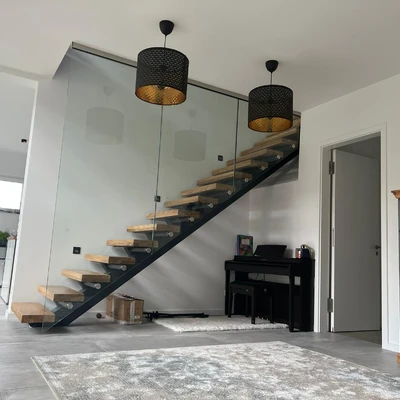 Moderne Treppe mit Glasbrüstung und Pendelleuchten