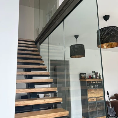 Moderne Treppe mit Glasbrüstung und Kronleuchtern