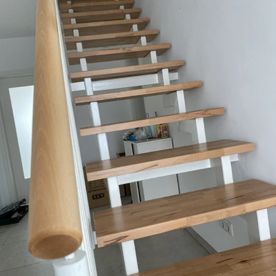 Holztreppe mit Geländer und flachen Trittflächen in einem modernen Haus
