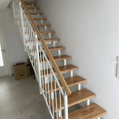 Hölzerne Treppe mit weißem Geländer in hellem Flur
