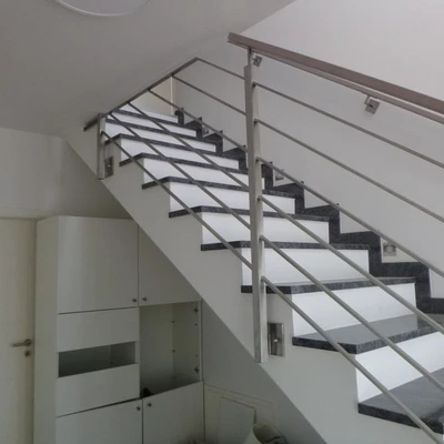 Moderne Treppe mit Metallgeländer in weißem Interieur