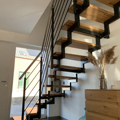Modernes Treppenhaus mit Holzstufen und schwarzem Geländer