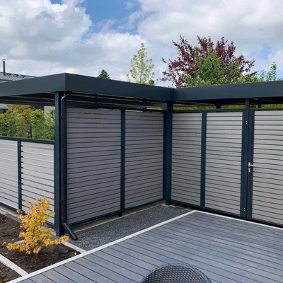 Moderne Gartenumzäunung mit Holzterrasse unter blauem Himmel