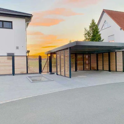 Moderne Einfamilienhäuser mit Carport und Sonnenuntergang