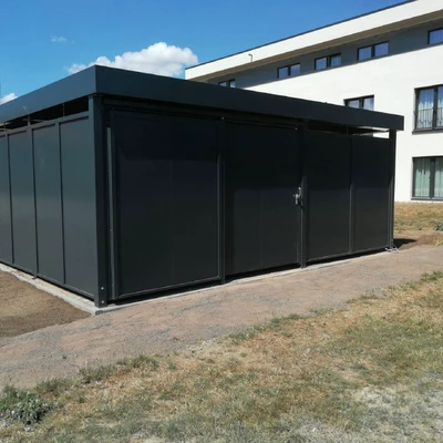 Schwarzes, modernes Gebäude neben einem weißen Neubau