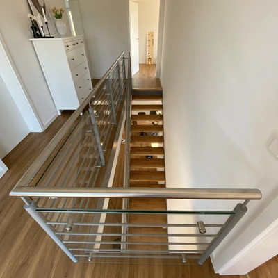 Moderner Edelstahl-Geländer an begehbare Treppe mit weißer Wand
