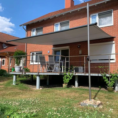 Moderne Überdachung an einem Backsteinhaus mit Terrasse