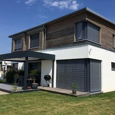 Modernes Wohnhaus mit Holzfassade, Vorhangrollos und Garten