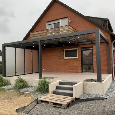 Modernes Haus mit überdachtem Wohnbereich und Holzterrasse