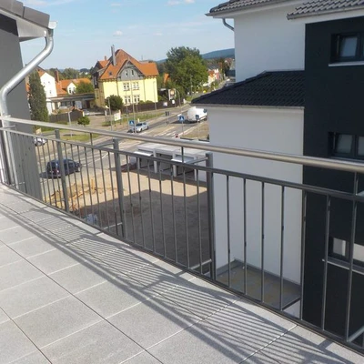 Balkon mit Ausblick auf Wohnbebauung an sonnigem Tag