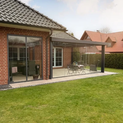 Anbau mit Glasüberdachung an Backsteinhaus mit Garten
