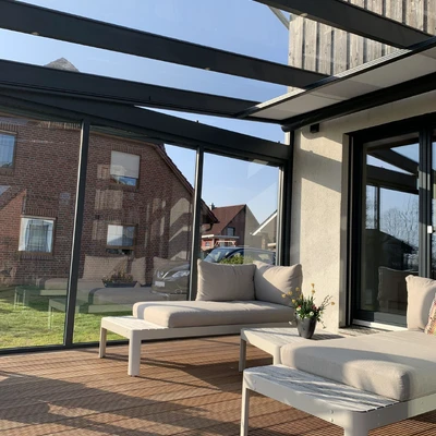 Sonnenheller Außenwohbereich mit Lounge-Möbeln und Blick auf Wohngebiet