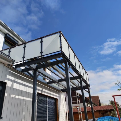 Modernes schwarzes Metallgestell für einen überdachten Anbau an eine weiße Fassade