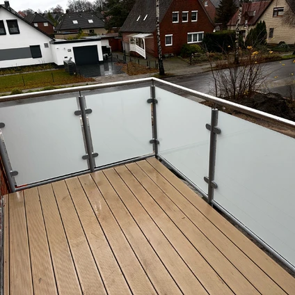 Holzterrasse mit transparentem Geländer und Blick auf die Häuser einer Nebenstraße