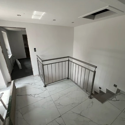 Modernes Interieur mit weißen Marmorböden einem Holzgeländer und einer Treppenanlage in minimalistischem Stil