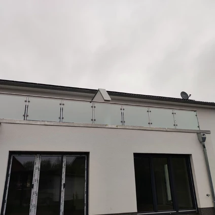 Weiße Fassade unter grauem Himmel mit horizontaler Fensterstruktur und großen Fenstern