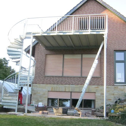 Metalltreppe und Balkonbau an einem Backsteingebäude auf einer Baustelle
