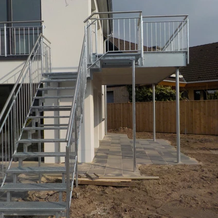 Stahltreppen und weißes Geländerbauwerk vor einem Haus auf Baustelle