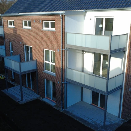 Modernes Wohnhaus mit gemischter Architektur aus rotem Backstein und weißer Fassade mit Balkonen