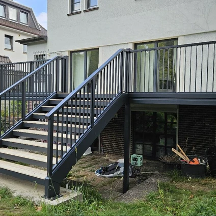 Neue schwarze Metalltreppe zu einem modernen hellen Gebäude mit Geländer