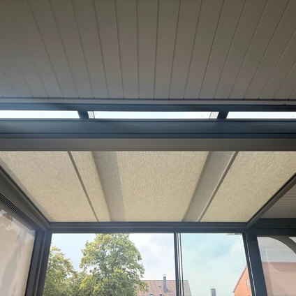Moderne Dachkonstruktion mit Lichtelementen und Blick auf Bäume und Gebäude