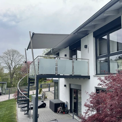 Moderne Architektur mit weißer Fassade Balkon großem Fenster und grüner Umgebung