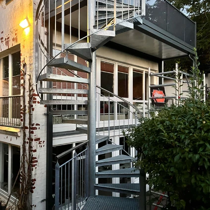 Fassadenansicht Metalltreppe und moderne Architektur an einem älteren gemauerten Gebäude