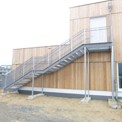 Metalltreppe an modernen Holzfassade-Gebäude im Bau auf einer Baustelle
