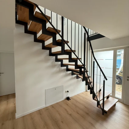 Modernes Treppendesign mit Holzstufen und schwarzem Geländer in heller Wohnung