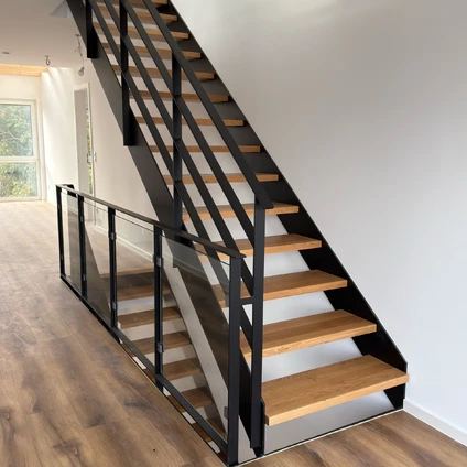 Moderne Treppe aus schwarzem Metall und Holz mit minimalistischem Geländer in hellem Innenraum