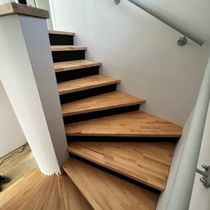 Elegant Treppe mit Holztrittflächen und schwarzen Kontrastakzenten im modernen Design