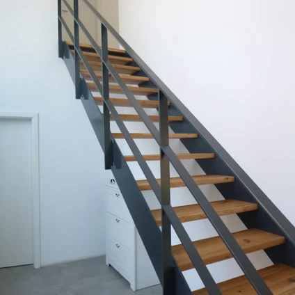 Moderne Treppe mit Holztrittflächen und schwarzem Metallgeländer in hellen Wänden