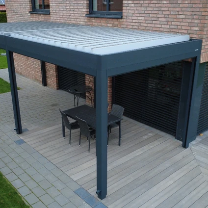 Moderne graue Pergola mit Tisch und Stühlen auf einem hölzernen Patio vor einem Ziegelhaus