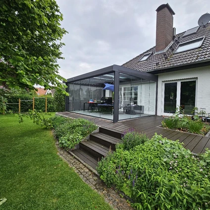 Moderne Anbauveranda an einem traditionellen Haus mit Garten Holzstufen und üppigem Grün