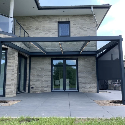 Modernes Wohnhaus aus Ziegelstein mit dunklem Metallüberdachung großen Fenstern und Terrassenbereich