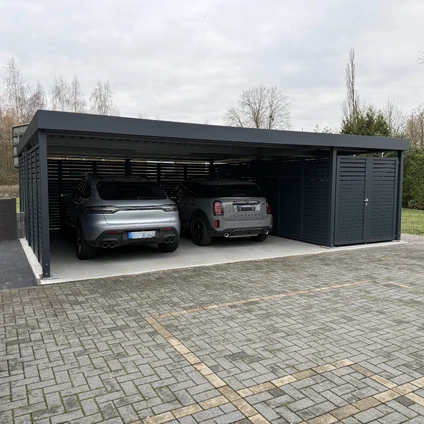 Modernes Carport-Design schützt zwei SUVs unter einem dunklen Dach auf einem gepflasterten Grundstück