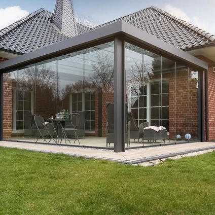 Modulares Glas-Wintergarten-Anbau an einem Wohnhaus mit Terrasse und Gartenmöbeln