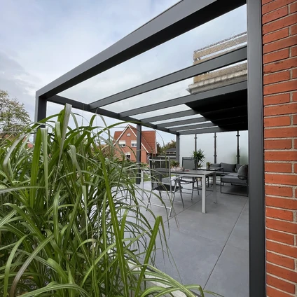 Schwarze Pergola über einem modernen Gartenbereich mit Sitzmöbeln viel Grün und Ziegelwänden