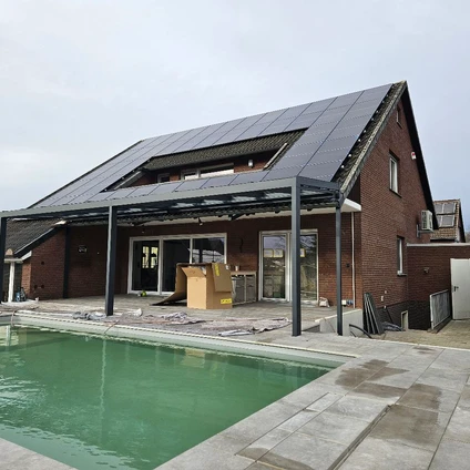 Modernes Haus mit Solar-Dach und Swimmingpool aufgenommen bei bewölktem Himmel