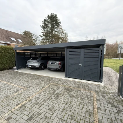 Überdachter Carport mit zwei Stellplätzen und geschlossener Garage an einer gepflasterten Einfahrt