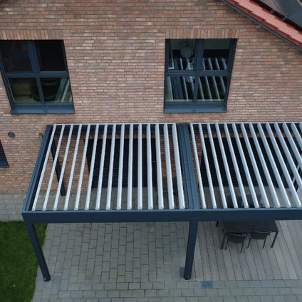Modernes Outdoor-Tischmöbelstück vor Ziegelwand mit Fenstern und Pflasterboden auf dem Patio